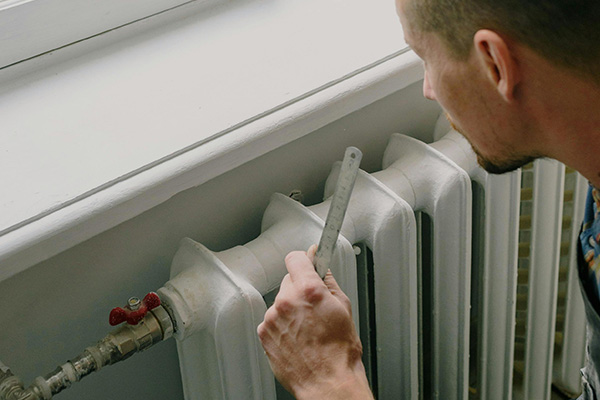 Man repairs a radiator in an apartment